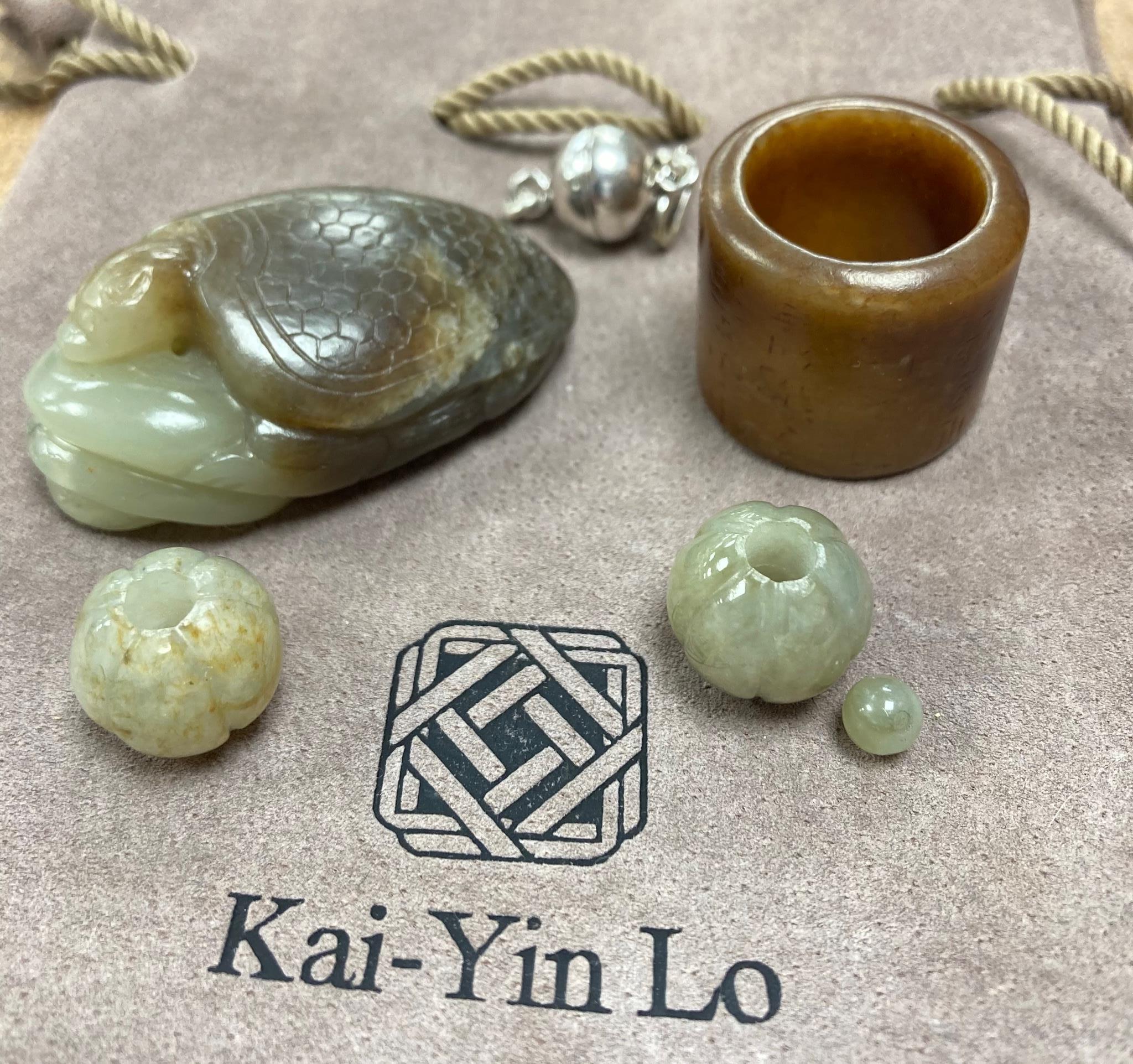 Kai Yin Lo of Hong Kong, a jade turtle and snake pendant, archer’s ring and two beads, formerly strung on a necklace together with a hardstone necklace